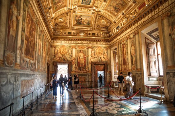 Golden frescoed hall with visitors