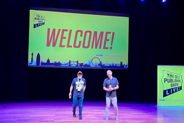 welcome sign on the stage and two authors who were in charge of the conference at that time